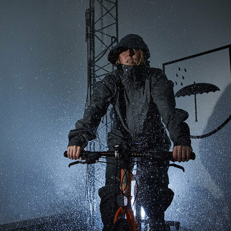 A woman cycling in a rain chamber